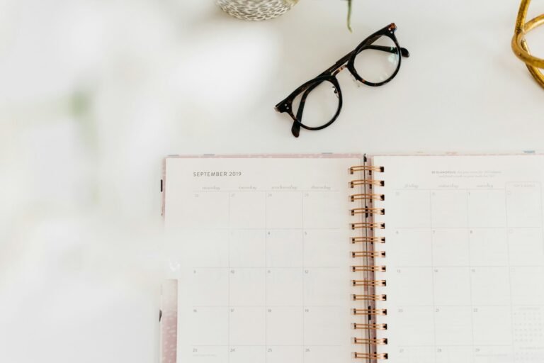 Open monthly planner with glasses on a desk