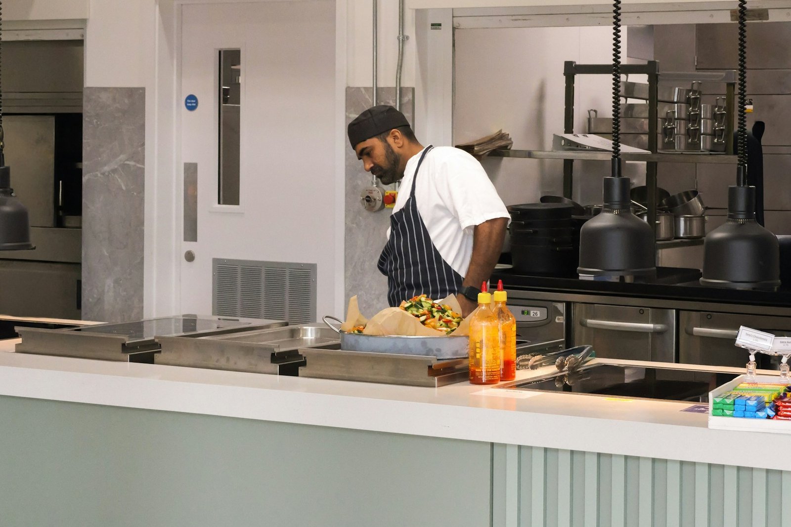 Cook preparing food at a commercial kitchen counter