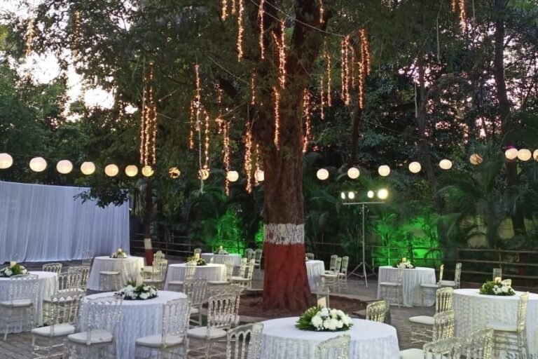 String-lit tree and round banquet tables at an outdoor Grandeur Hospitality event