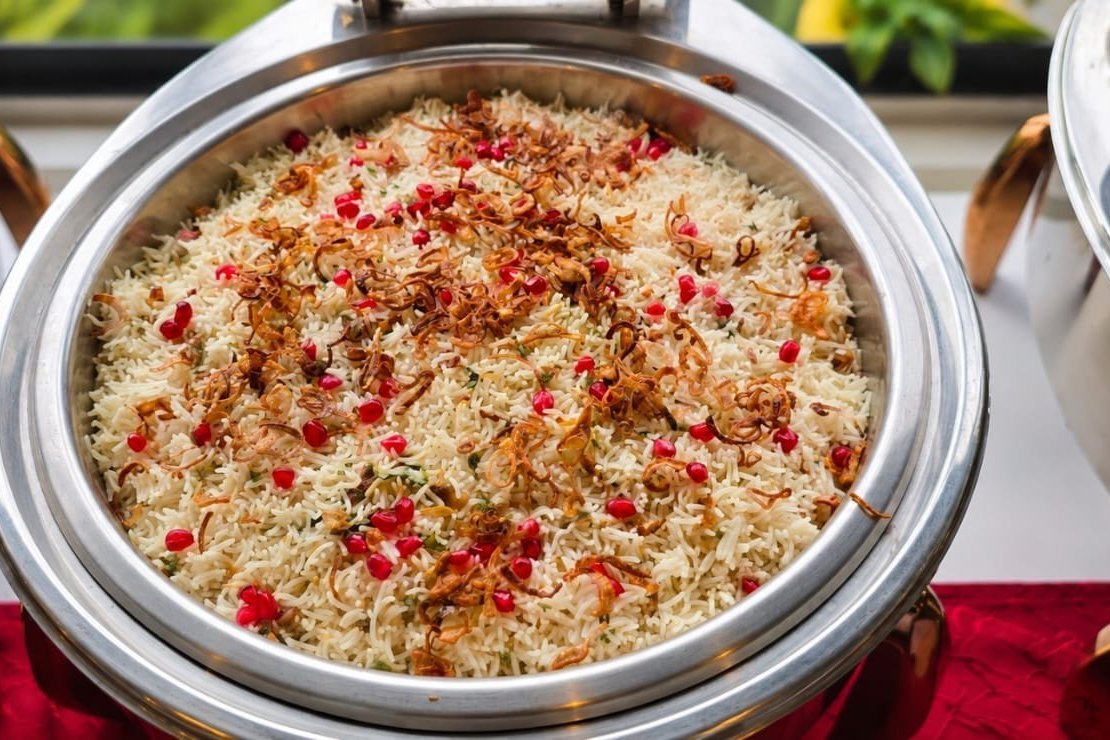 Pomegranate and saffron rice pulao in a chafing dish at a buffet