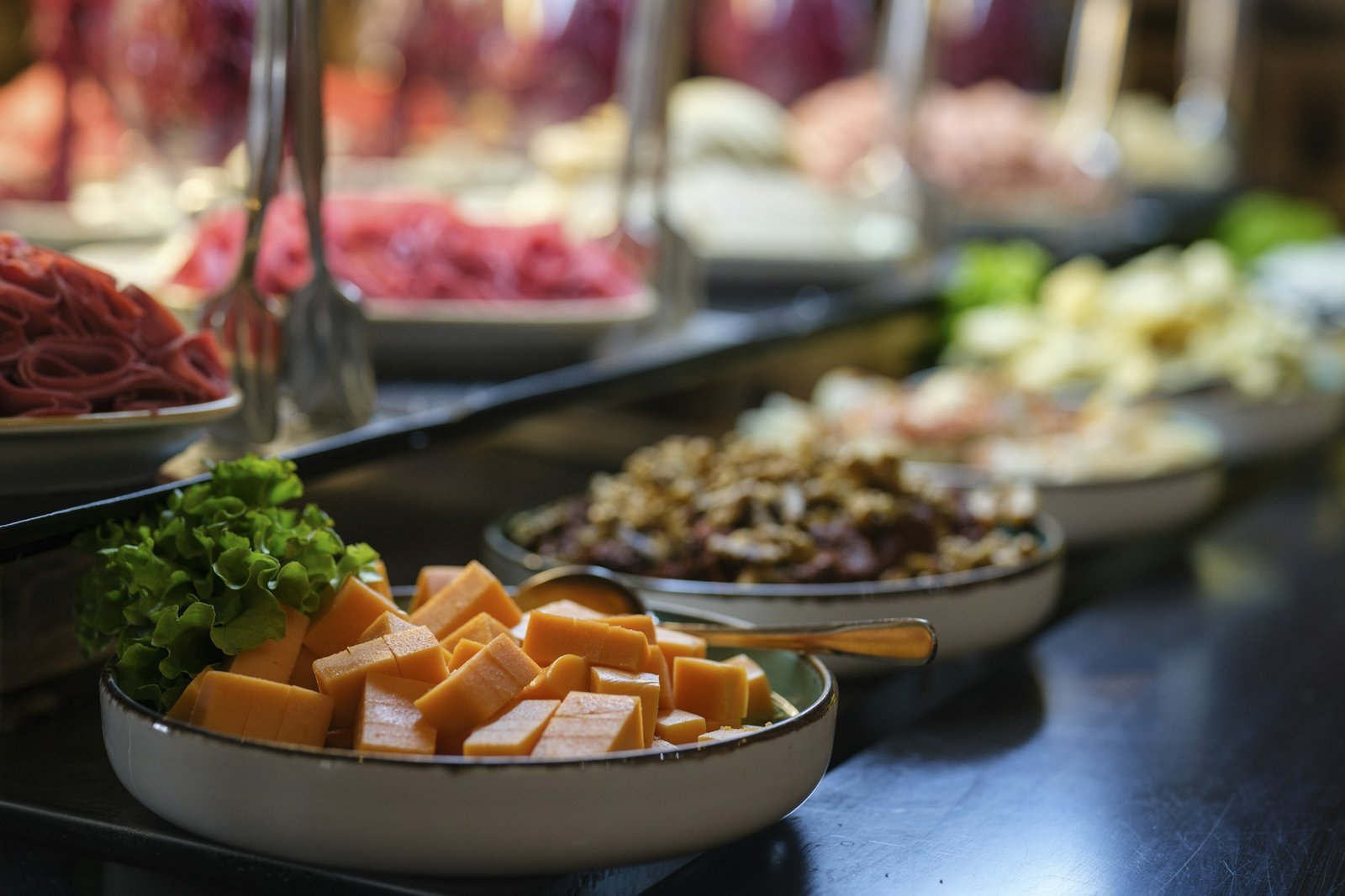 Long buffet line of fresh salads and dishes in serving bowls