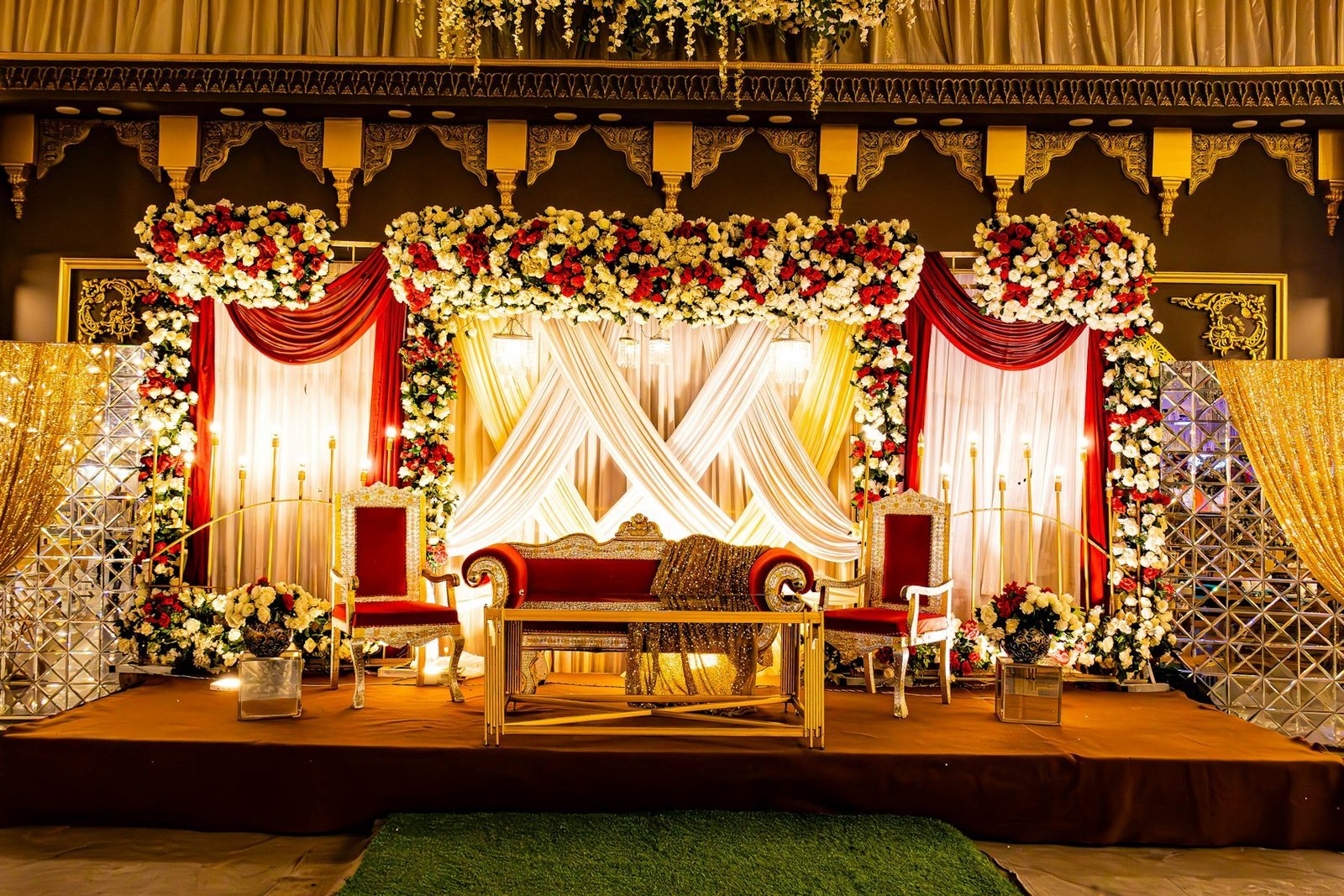 Ornate Indian wedding stage decorated with flowers and drapes